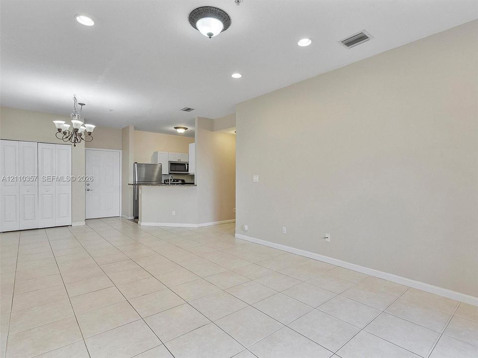 Interior space featuring neutral tile flooring, recessed lighting, a multi-light chandelier, and built-in closet cabinetry