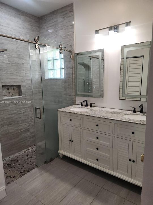 Dual-sink vanity with louvered cabinet doors, stone-composite countertop, and two integrated rectangular mirrors