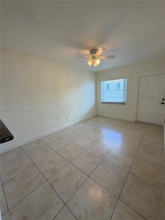 Ceramic tile flooring, multi-panel interior door, and ceiling fan with integrated light fixture