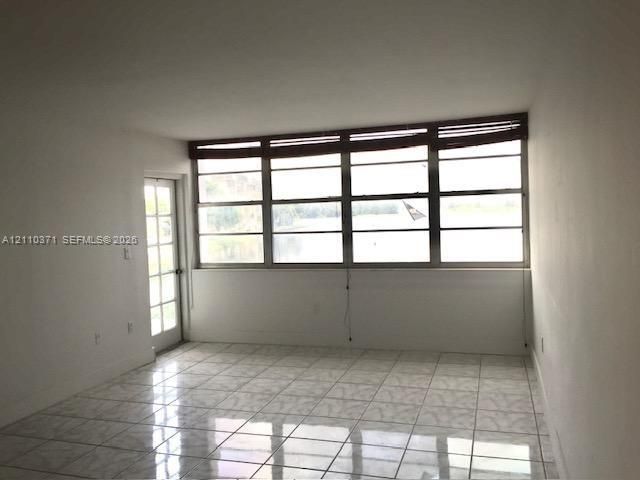 Interior space featuring ceramic tile flooring, a multi-pane fixed window array, and a glass-paned exterior door