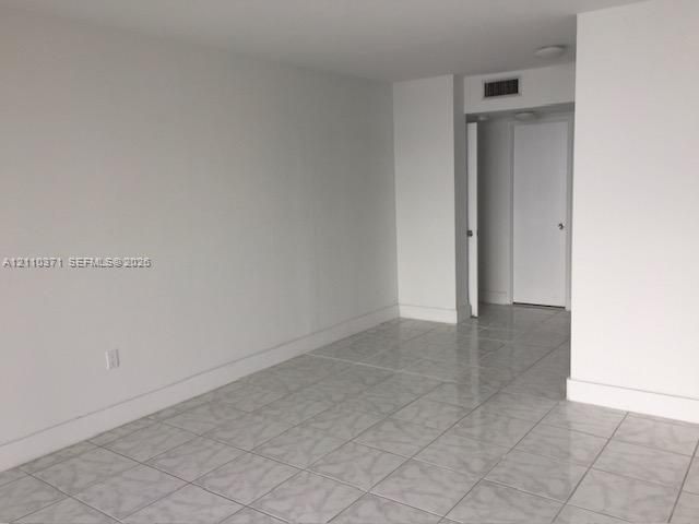 Interior space featuring neutral wall tones, large-format ceramic tile flooring, and solid-core doors