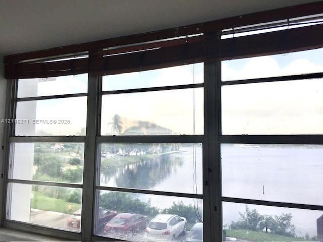 Expansive three-panel horizontal slider window featuring a metallic frame and integrated wood-finish valance