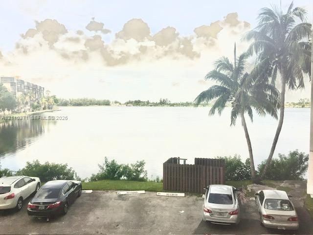 Waterfront setting featuring a prominent lake, mature palm trees, and landscaped grounds