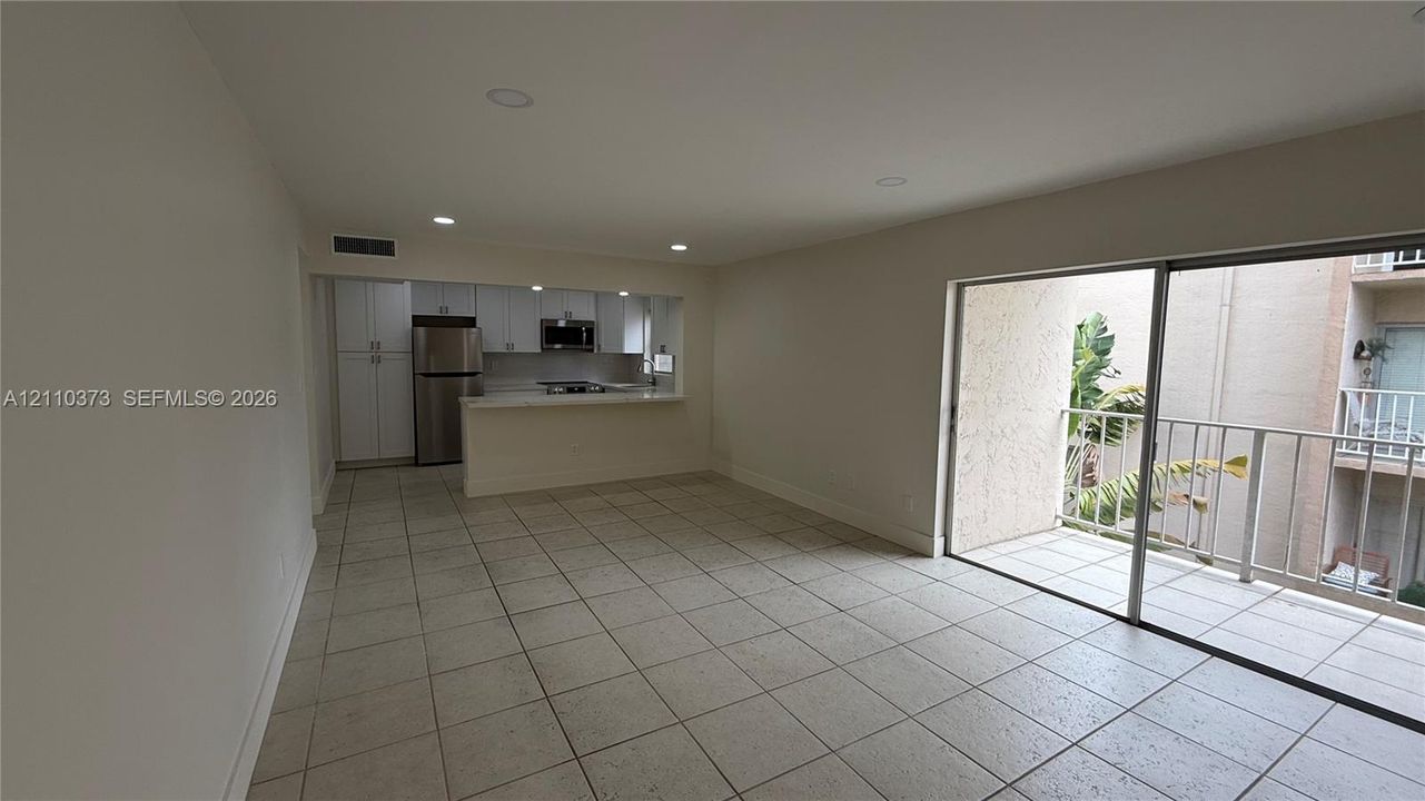 Kitchen featuring white shaker-style cabinetry, stainless steel appliances, and a breakfast bar