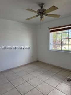 Neutral-toned ceramic tile flooring, multi-pane window with wood-finish blinds, and a multi-blade metal ceiling fan