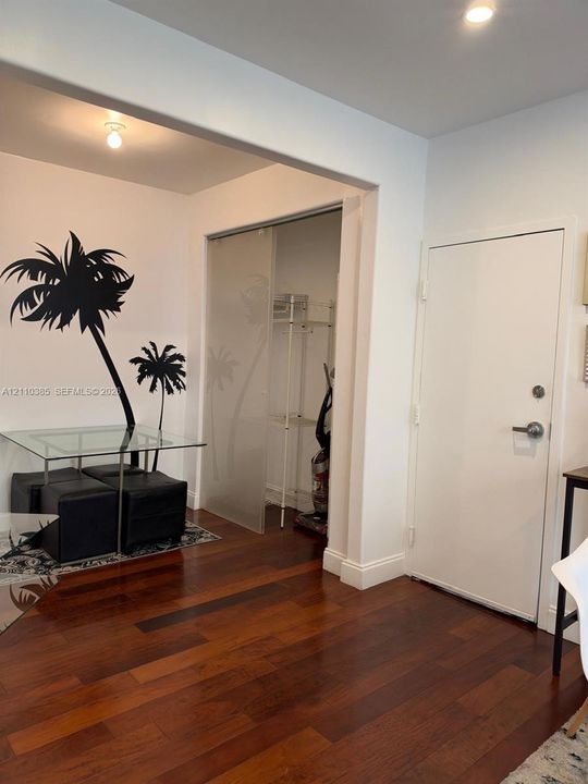 Wood-finish flooring, recessed ceiling lighting, and a closet featuring frosted sliding glass doors