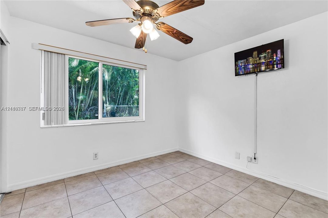 Ceramic tile flooring, neutral wall finishes, ceiling fan with integrated light fixture, and horizontal sliding window