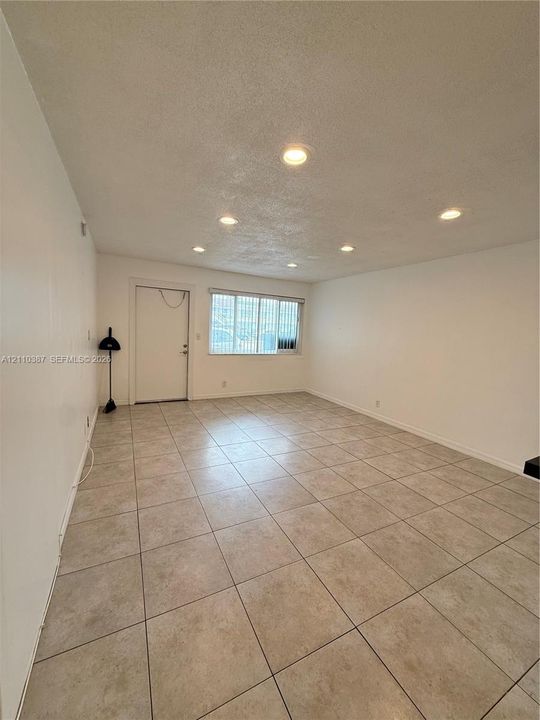 Neutral wall tones, ceramic tile flooring, and recessed ceiling lighting