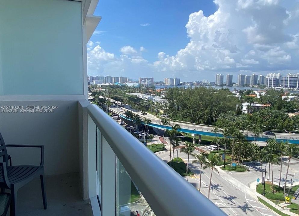 Private balcony featuring a glass-panel railing and concrete flooring