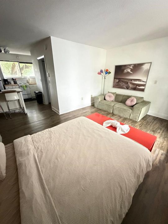 Wood-finish flooring, kitchen island, and white wall finishes