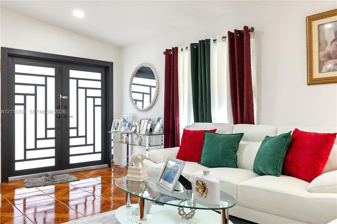 Double entry doors with geometric glass inserts, recessed lighting, and glossy parquet flooring