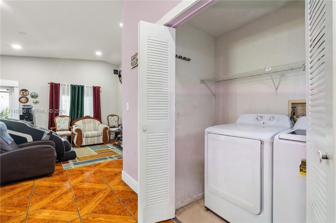 Laundry closet featuring bi-fold louvered doors, metal wire shelving, and wood-finish tile flooring
