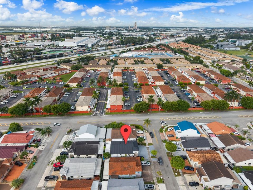 Aerial perspective of a multi-structure property featuring dark-toned roofing and paved surface parking