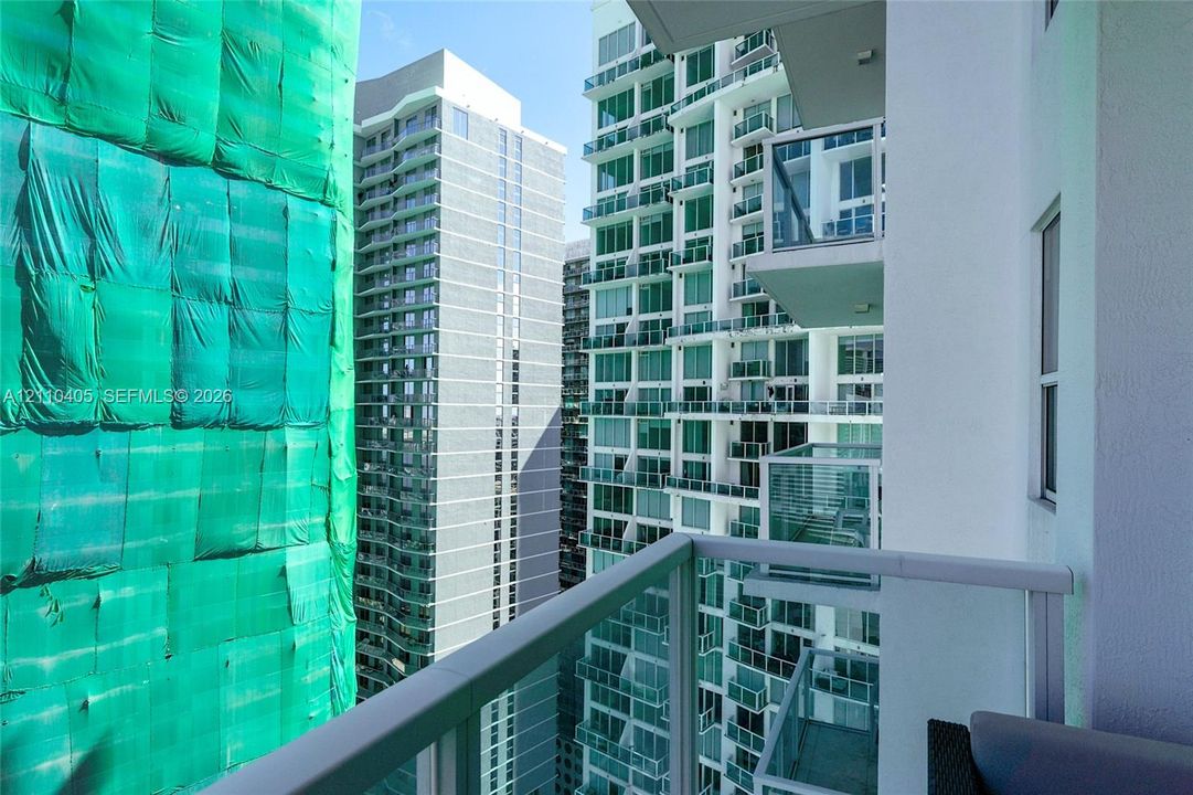 Private balcony featuring glass railings and white metal framing