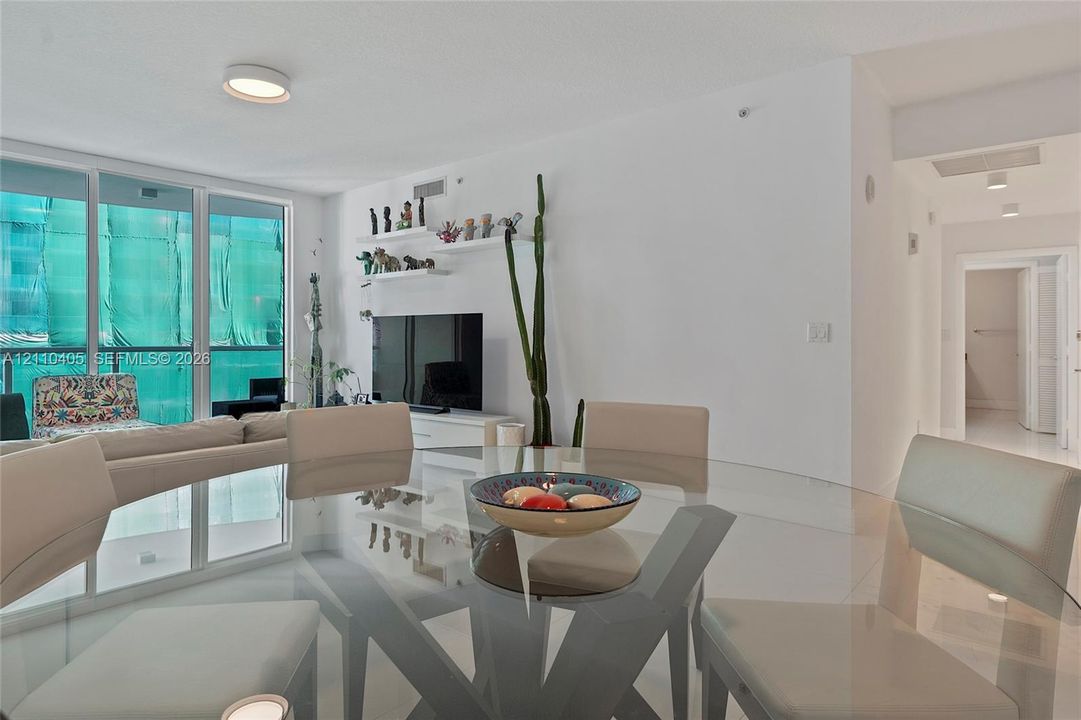 Open-concept floor plan featuring floor-to-ceiling glass sliding doors, recessed ceiling lighting, and crisp white walls