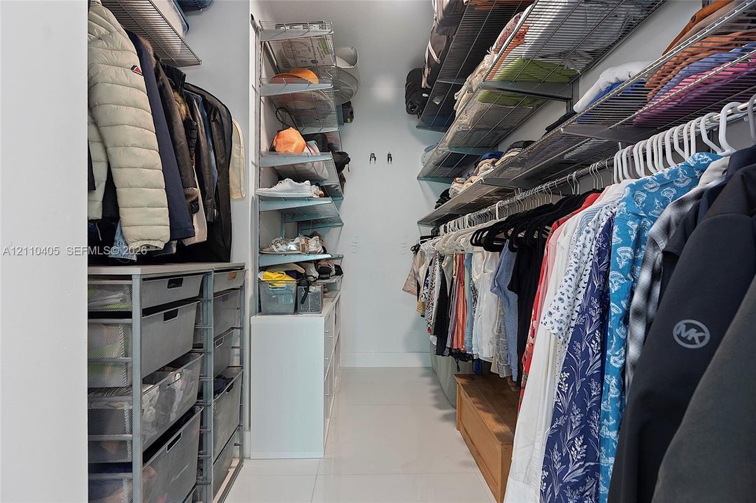 Walk-in closet featuring multi-tiered wire shelving, integrated modular storage units, and pull-out metal drawers