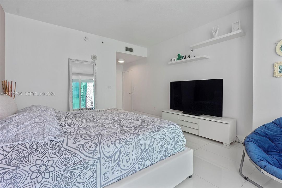 White stone-finish flooring, dual wall-mounted floating shelves, and a solid-core interior door