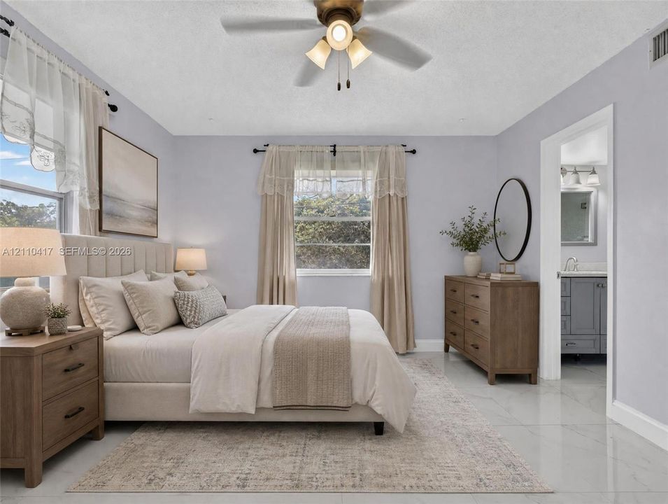 Neutral-toned bedroom featuring large-format tile flooring, a multi-blade ceiling fan with integrated lighting, and multiple windows