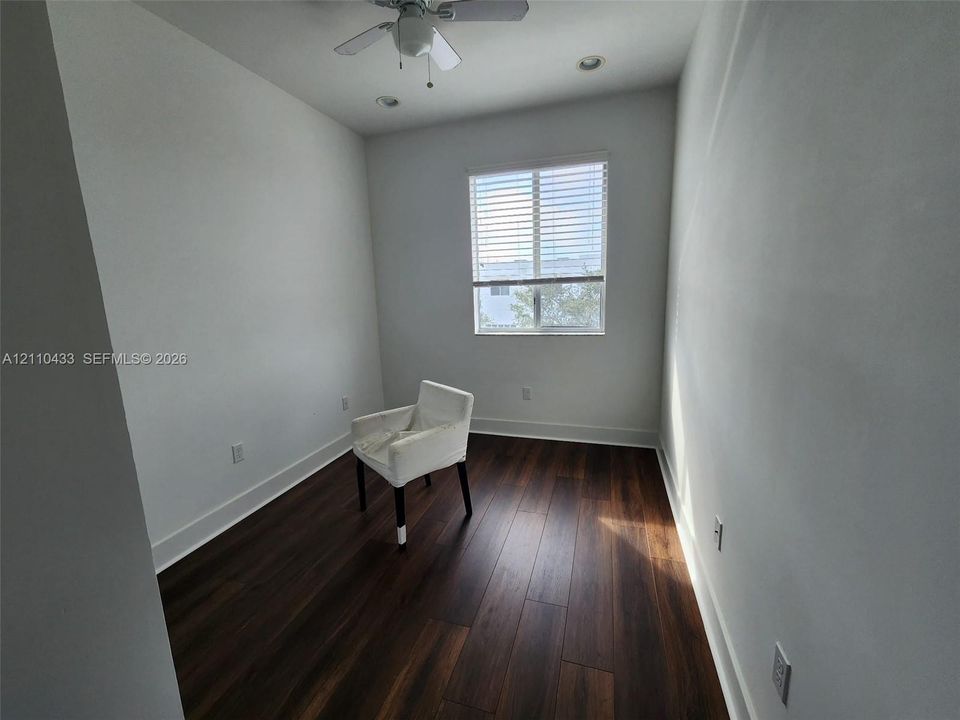 Room featuring wood-finish flooring, a single-pane window with horizontal blinds, recessed lighting, and a white ceiling fan