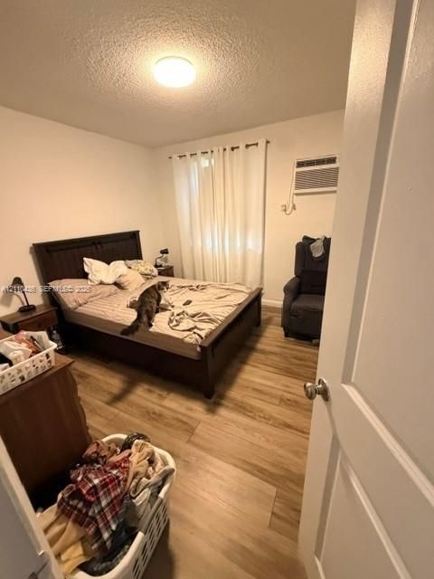 Wood-finish flooring, wall-mounted air conditioning unit, and ceiling-mounted light fixture