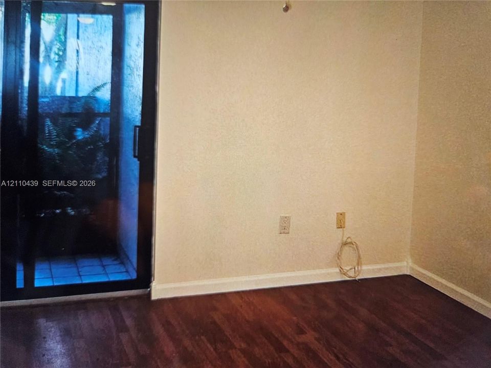 Interior space featuring dark-toned wood-finish flooring and a sliding glass door providing external access