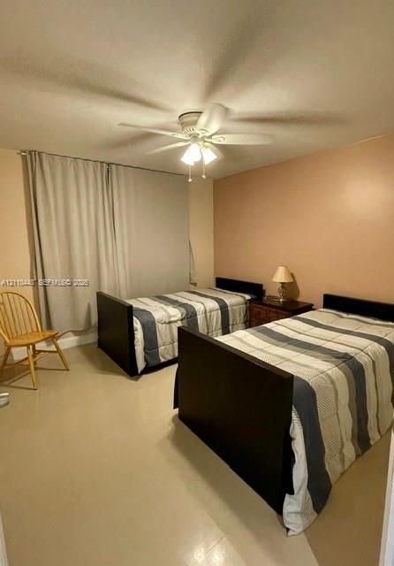 Room featuring neutral wall paint, smooth-finish ceiling, and ceiling-mounted light fixture with a central fan