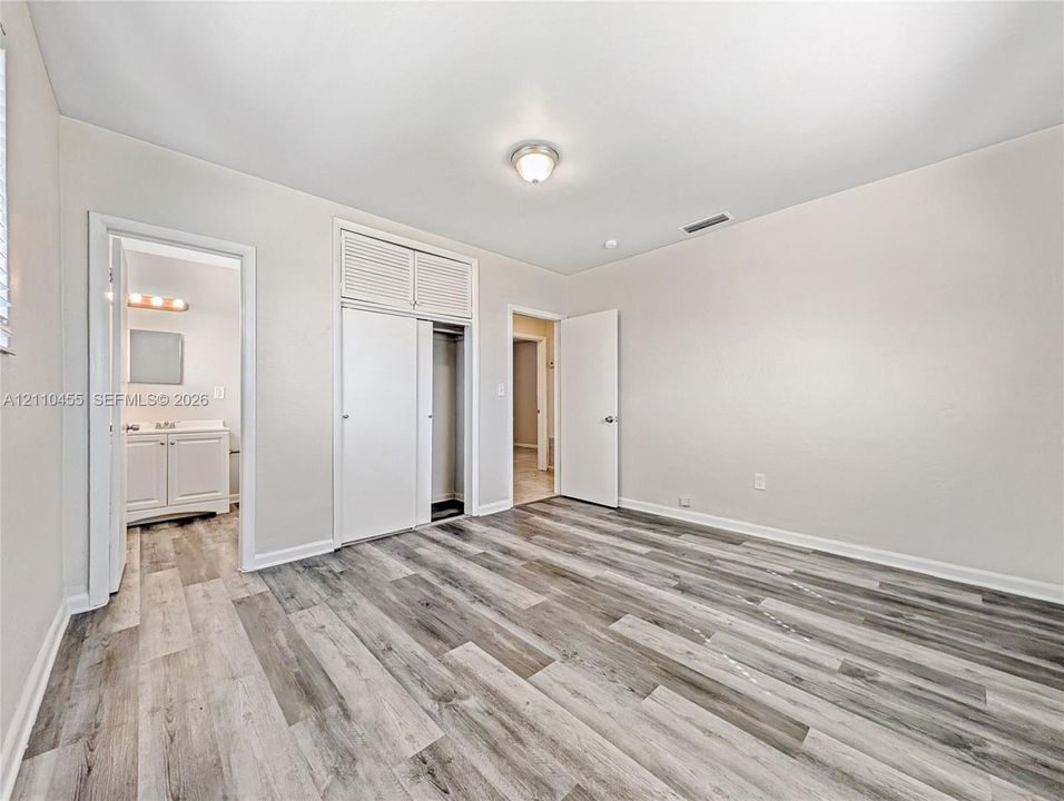Wood-finish flooring, dual-door closet with overhead storage, and ceiling-mounted light fixture