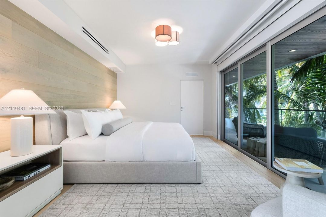 Wood-finish wall paneling, floor-to-ceiling sliding glass doors, recessed lighting, and flush-mount ceiling fixture