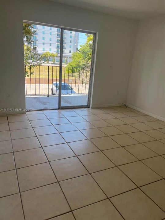 Ceramic tile flooring, sliding glass door, and metal balcony railing