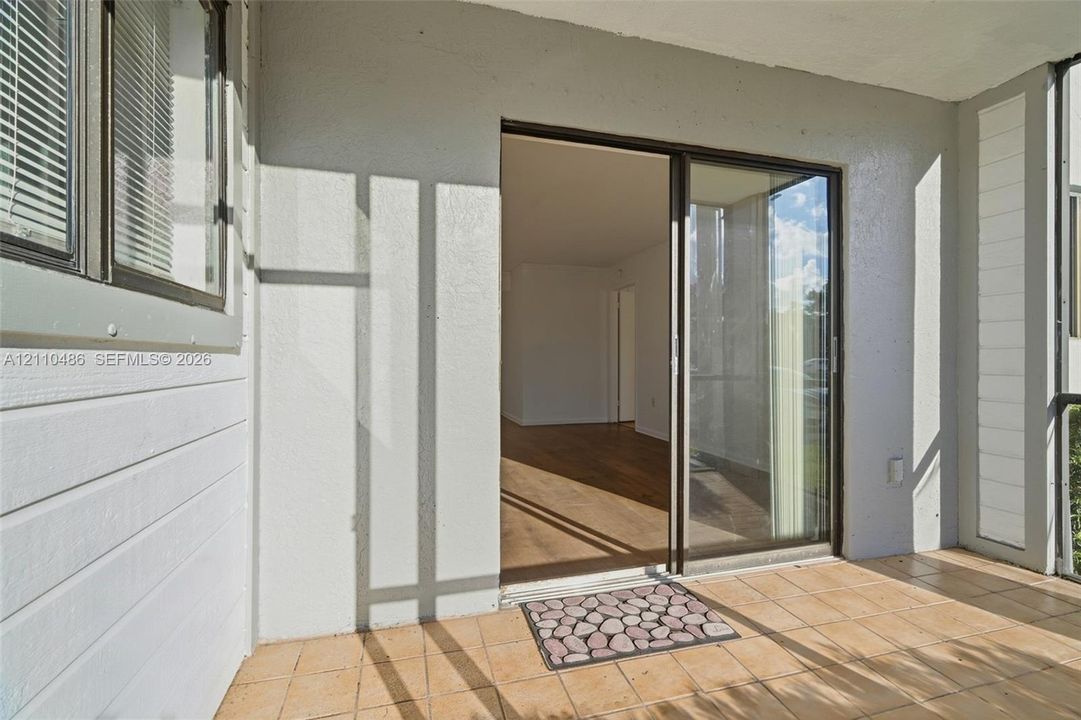 Screened-in porch featuring tile flooring, sliding glass door entry, and horizontal siding