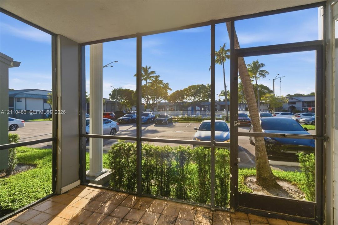 Screened-in porch featuring tile flooring, metal framing, and a full-height glass door