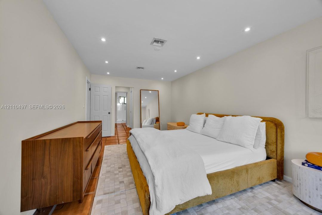 Neutral-toned room featuring recessed ceiling lighting, tile flooring, and a multi-panel door