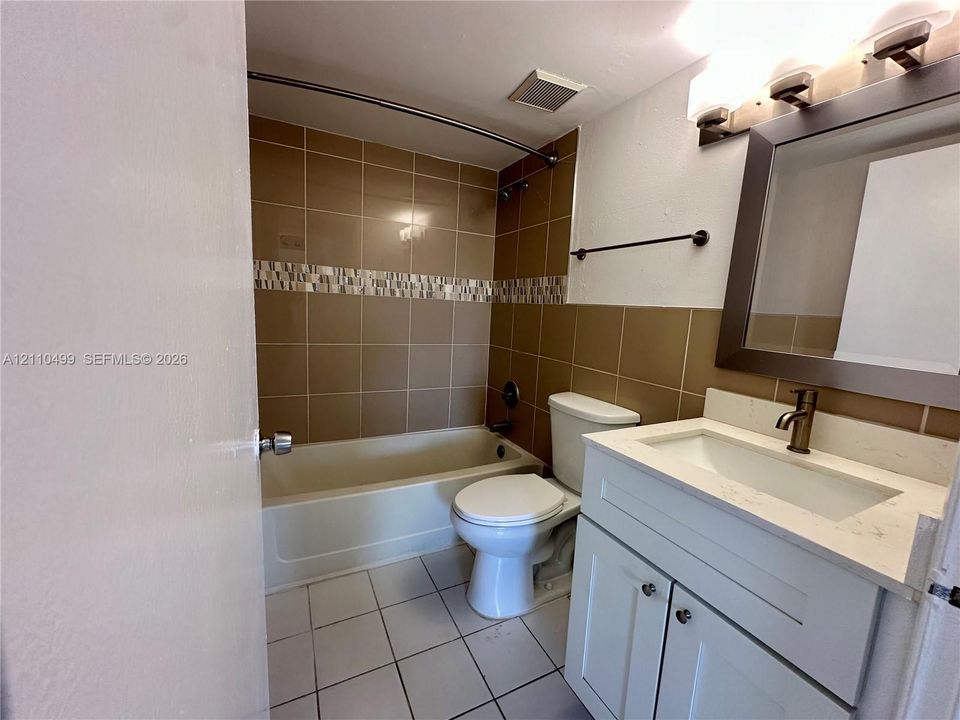 Bathroom featuring a vanity with a light-toned countertop, integrated basin, and bronze-finish hardware
