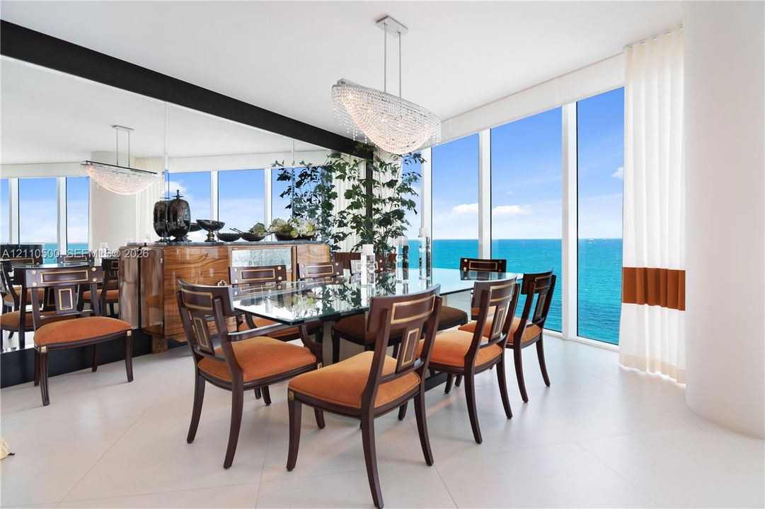 Floor-to-ceiling windows, large-format tile flooring, expansive wall mirror, and contemporary multi-tiered crystal pendant lighting