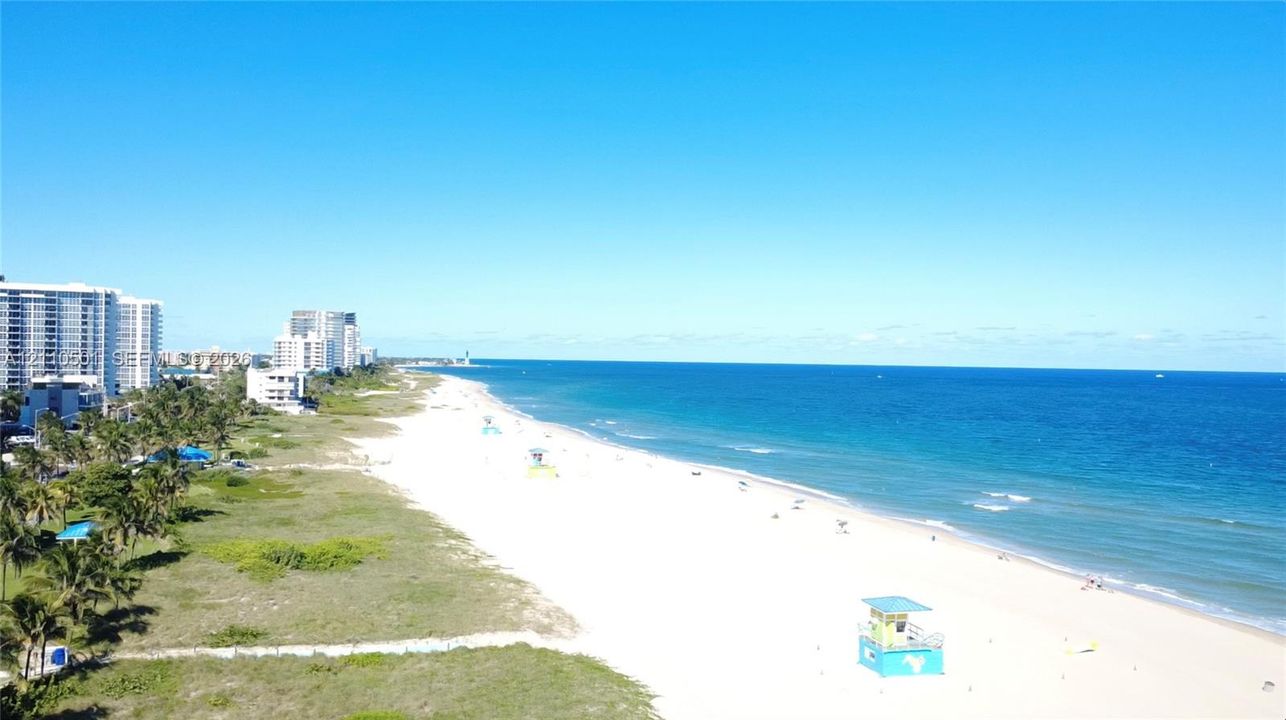 Coastal property featuring direct oceanfront access, expansive sandy beach, and mature palm trees