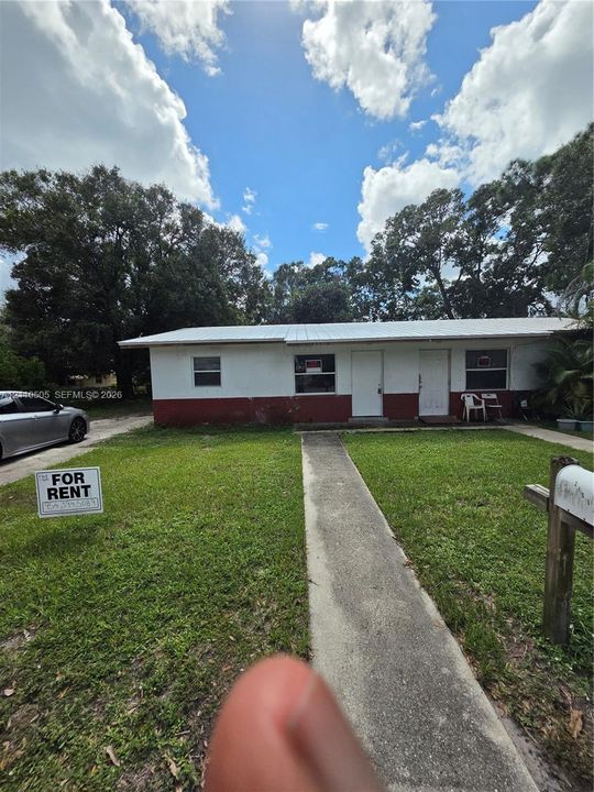Single-story exterior featuring a metal roof, two entry doors, and a concrete walkway