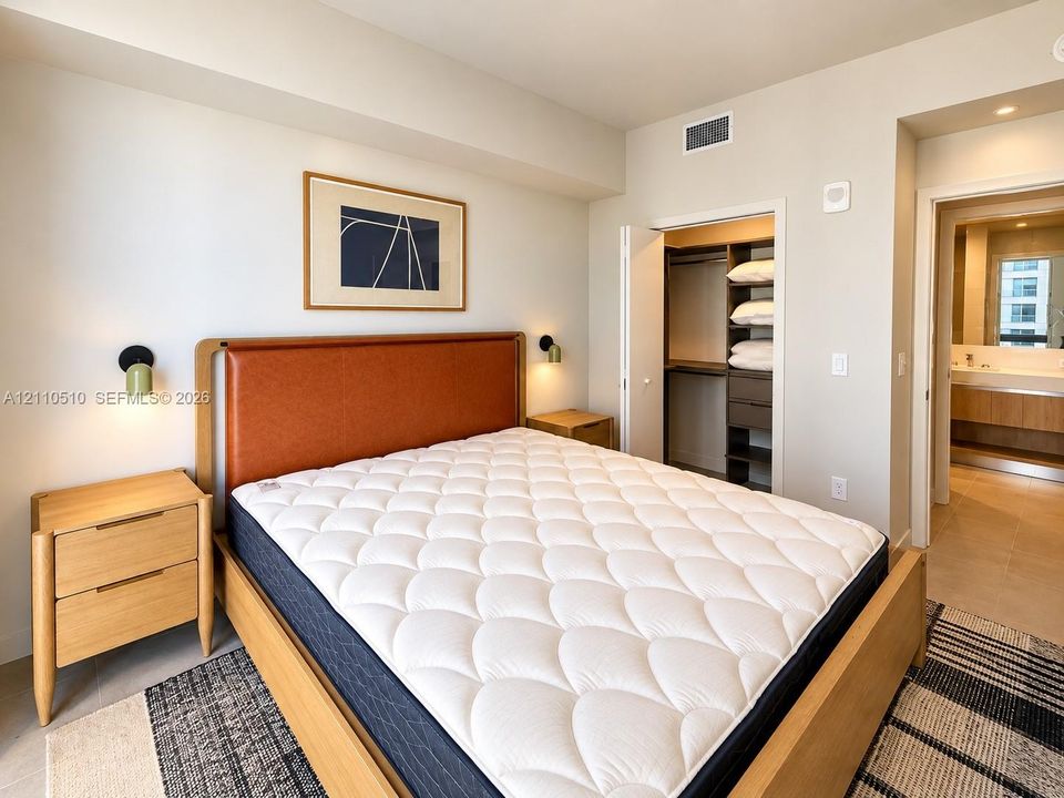 Bedroom featuring recessed lighting, wall-mounted sconces, and an integrated closet system with built-in shelving and drawers