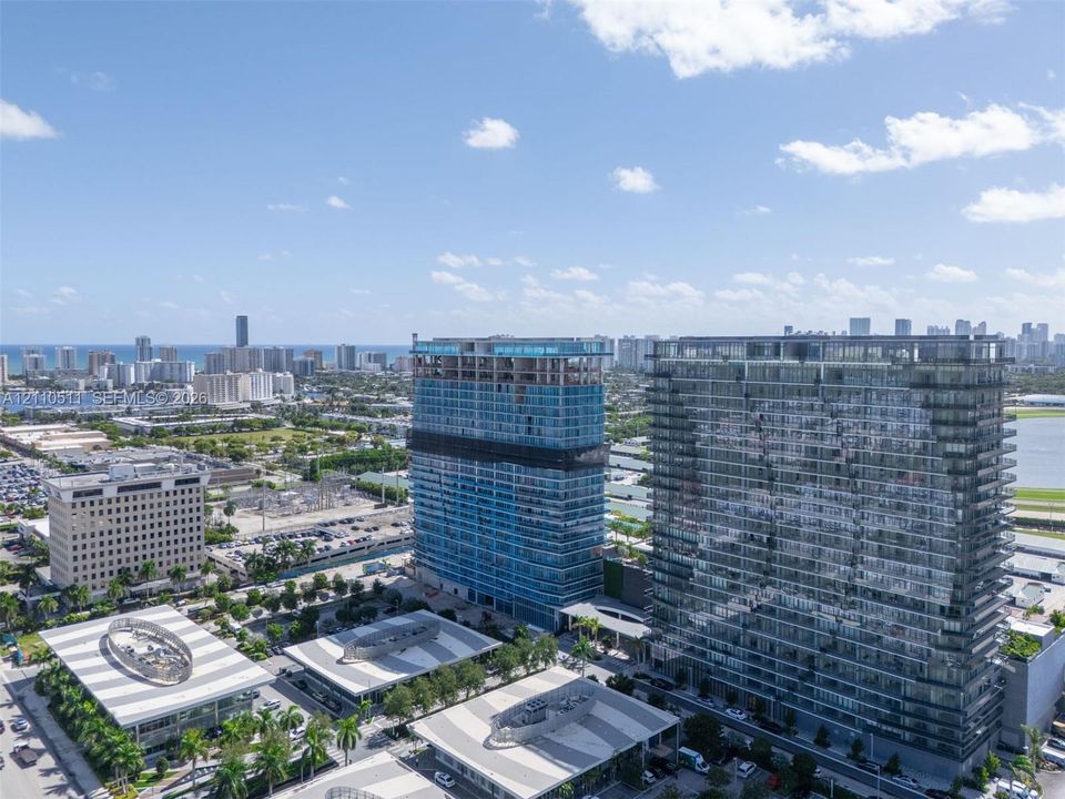 Aerial perspective of high-rise structures featuring glass-paneled facades and architectural symmetry