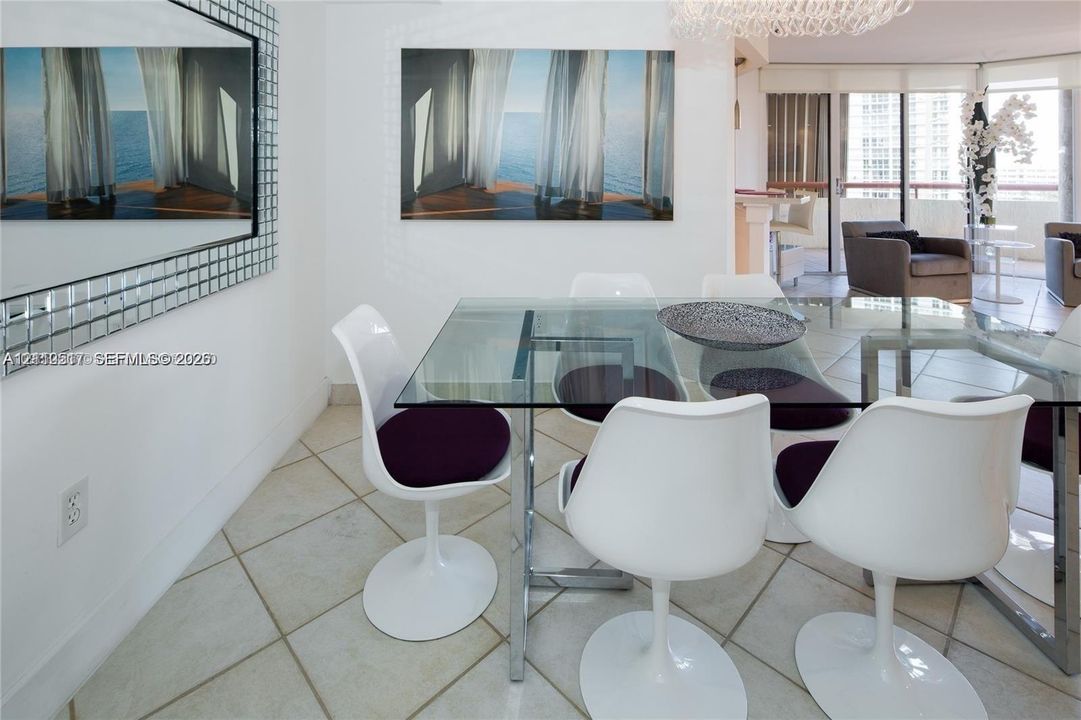 Large-format grid mirror with a metallic frame, expansive glass-paned sliding doors, polished tile flooring, and a contemporary crystal chandelier