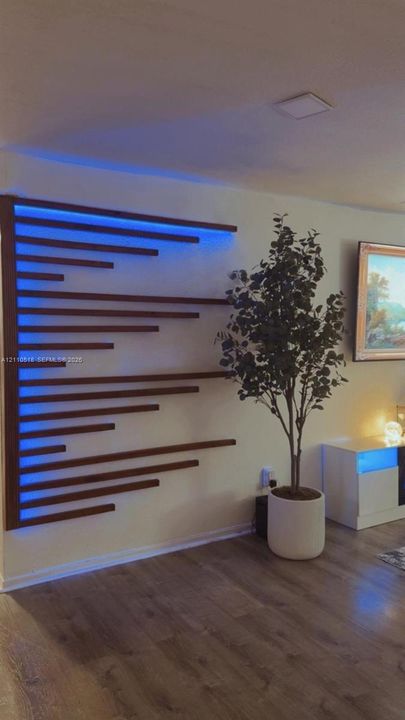 Custom wood slat wall feature with integrated recessed lighting and wood-finish flooring