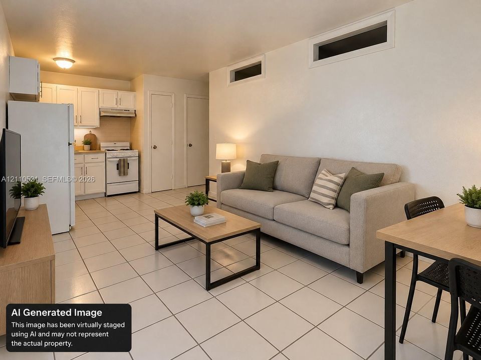 Open-concept kitchen featuring white cabinetry, light-toned countertops, and a white range, finished with ceramic tile flooring and high-placed rectangular windows