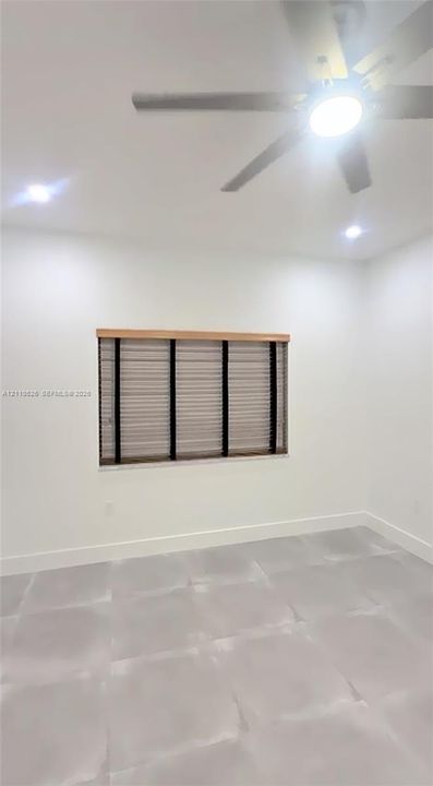 Interior room featuring large-format tile flooring, recessed lighting, and a multi-blade ceiling fan with an integrated light fixture