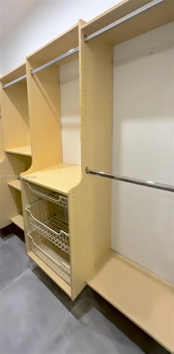 Custom closet system featuring light-finish laminate shelving, adjustable hanging rods, and integrated wire storage drawers