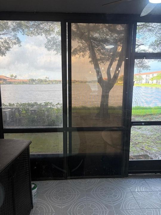 Screened-in patio with geometric tile flooring and full-height metal-framed screening