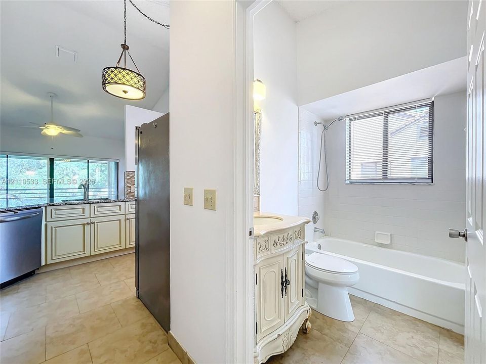 Kitchen features include cabinetry with crown molding, stone-finish countertops, and a pendant light fixture