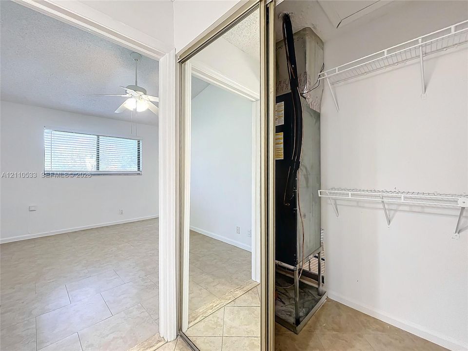 Sliding mirrored closet doors, tile flooring, and built-in wire shelving