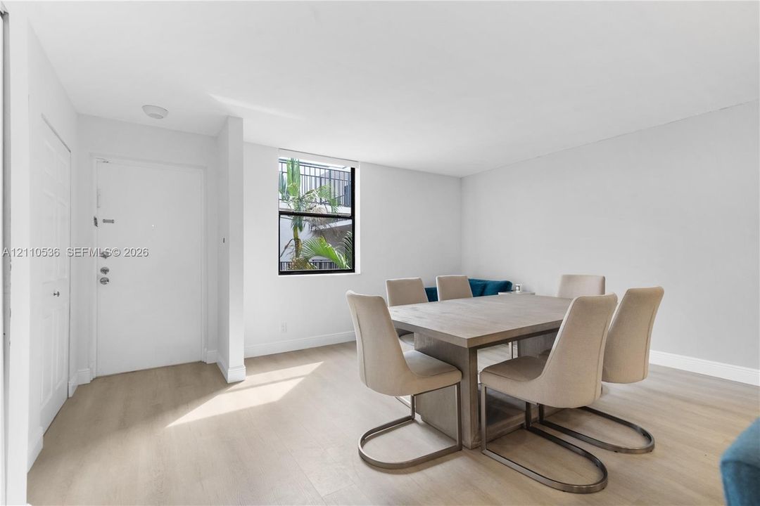Light-filled interior featuring wood-finish flooring, white walls, and a single-pane window
