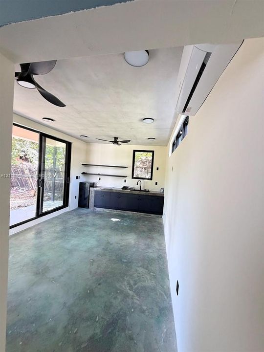 Hallway featuring neutral-toned tile flooring, smooth wall finishes, and a flush-mount ceiling light fixture