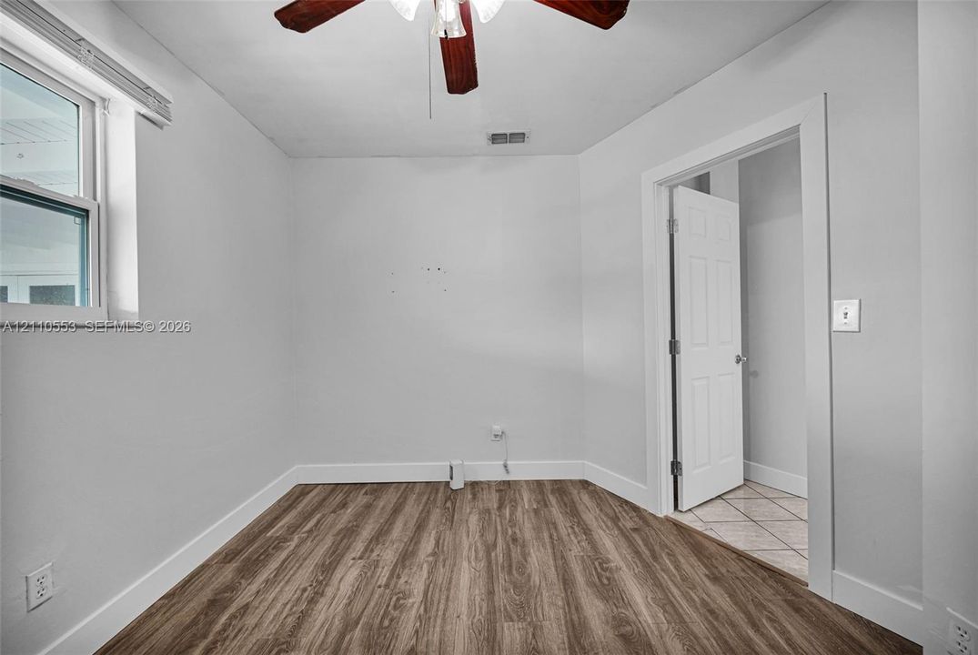 Room featuring wood-finish flooring, a ceiling fan, and a neutral color palette
