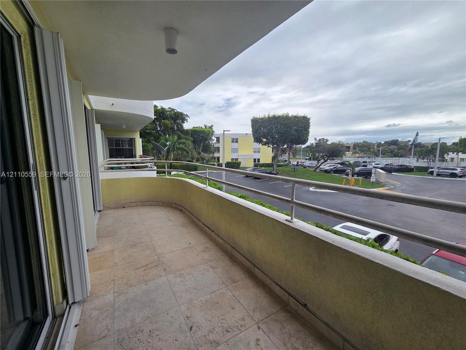 Curved balcony featuring stone tile flooring and a metal railing